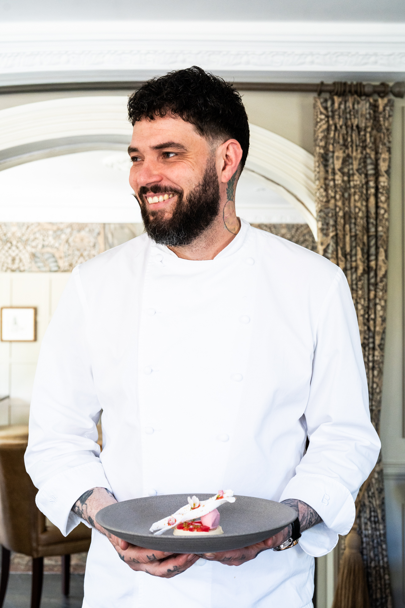 Gourmet plated dish with a glass of red wine on a wooden table in an elegant restaurant setting
